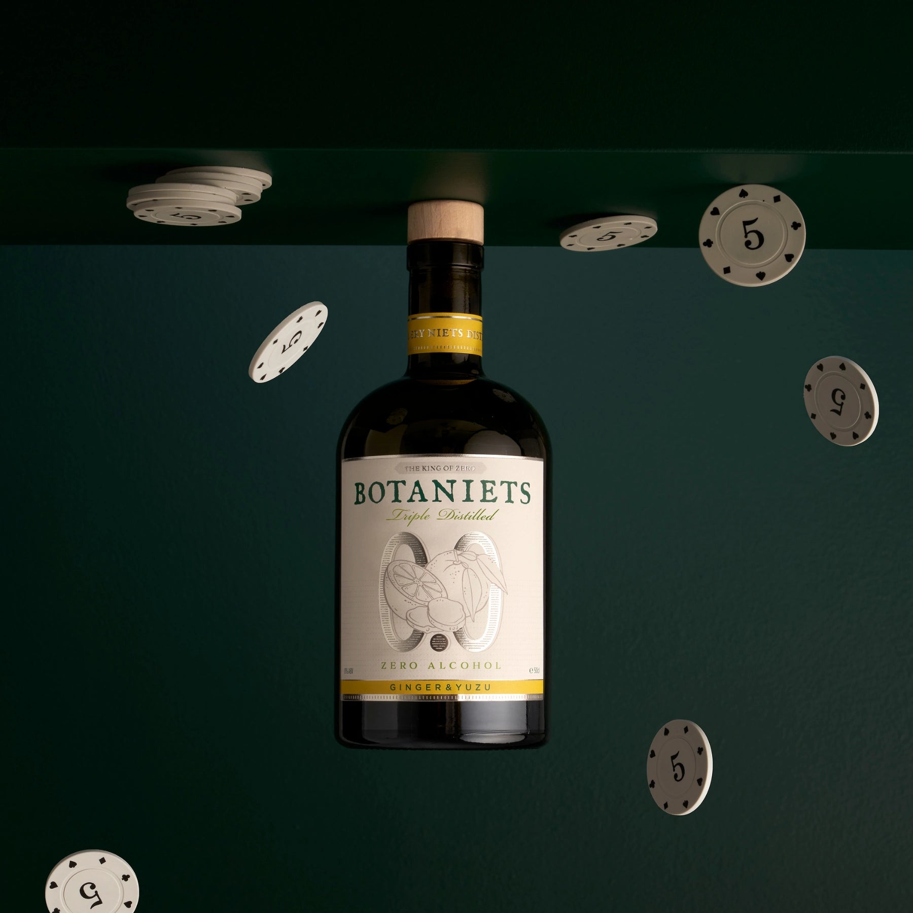 Botaniets Ginger and Yuzu alcohol-free botanical spirit bottle in creative composition with floating chips.