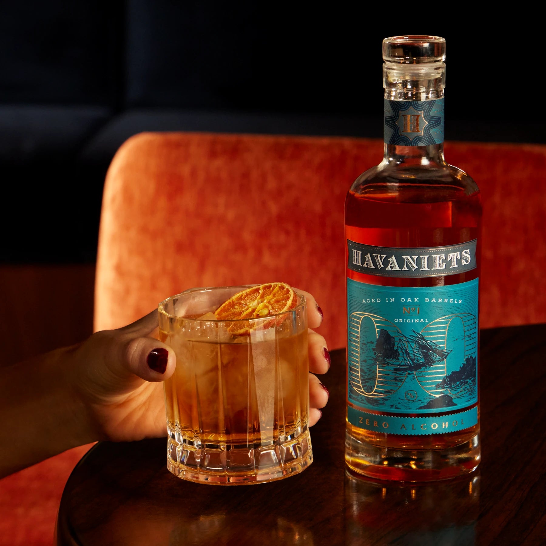 Havaniets Original alcohol-free rum-style spirit served over ice with orange in an old fashioned glass.