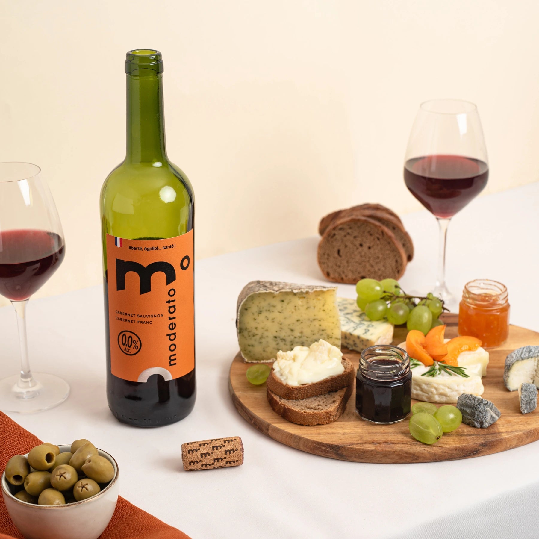 Moderato alcohol-free red wine paired with cheese, olives and bread, studio food pairing scene.