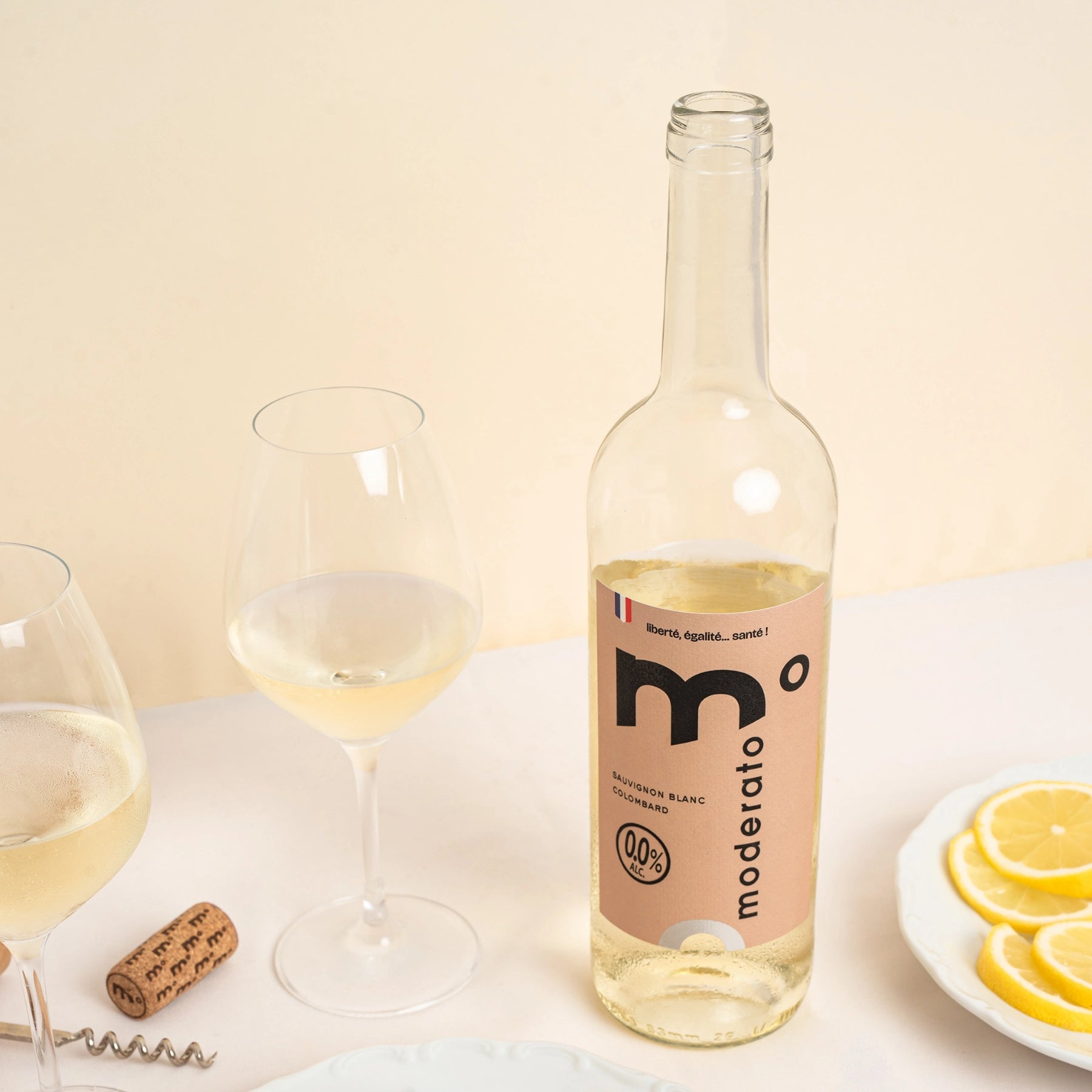 Moderato alcohol-free white wine with lemon slices and glasses, fresh and light serving scene.
