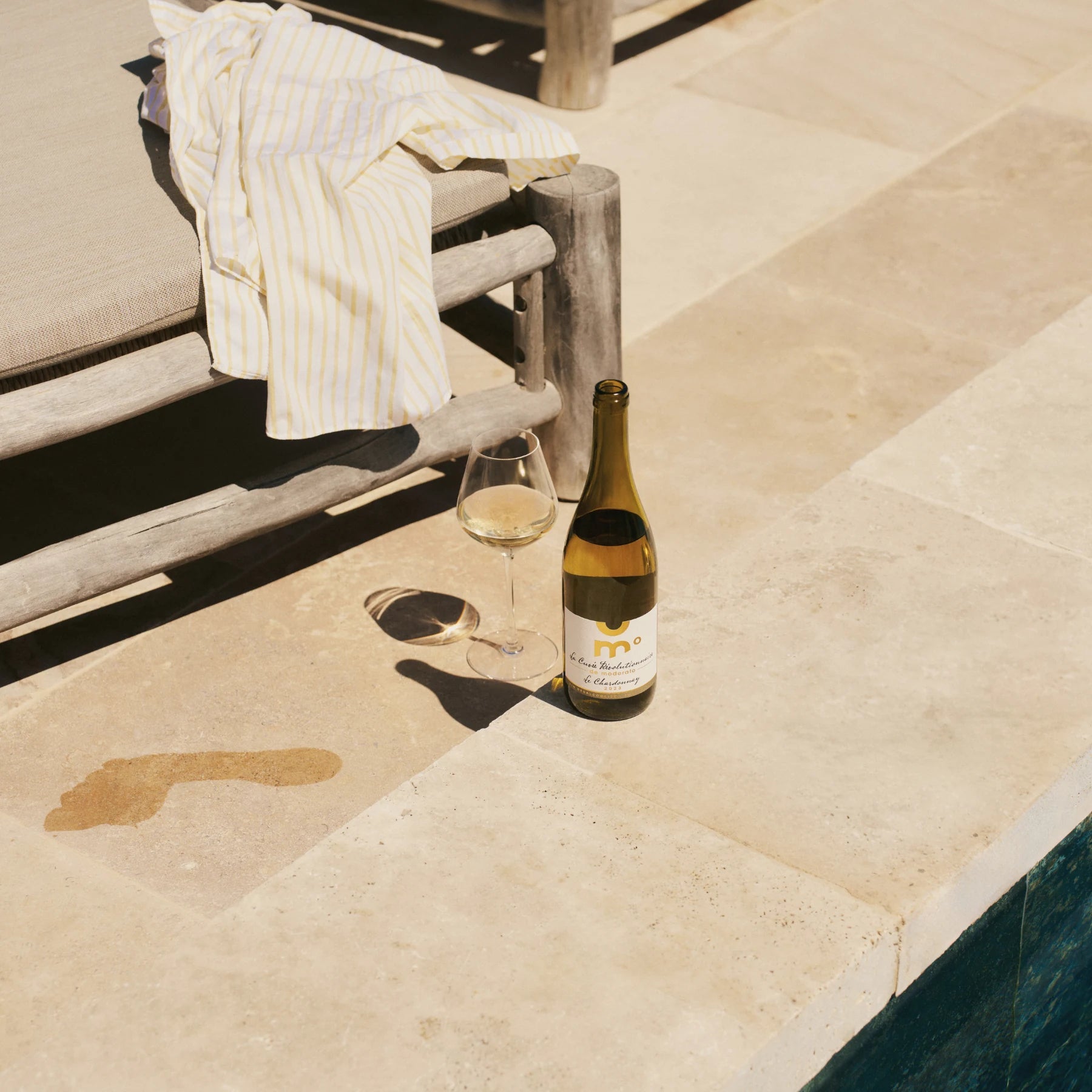 Moderato Chardonnay alcohol-free white wine served by the pool with a glass, relaxed summer setting.