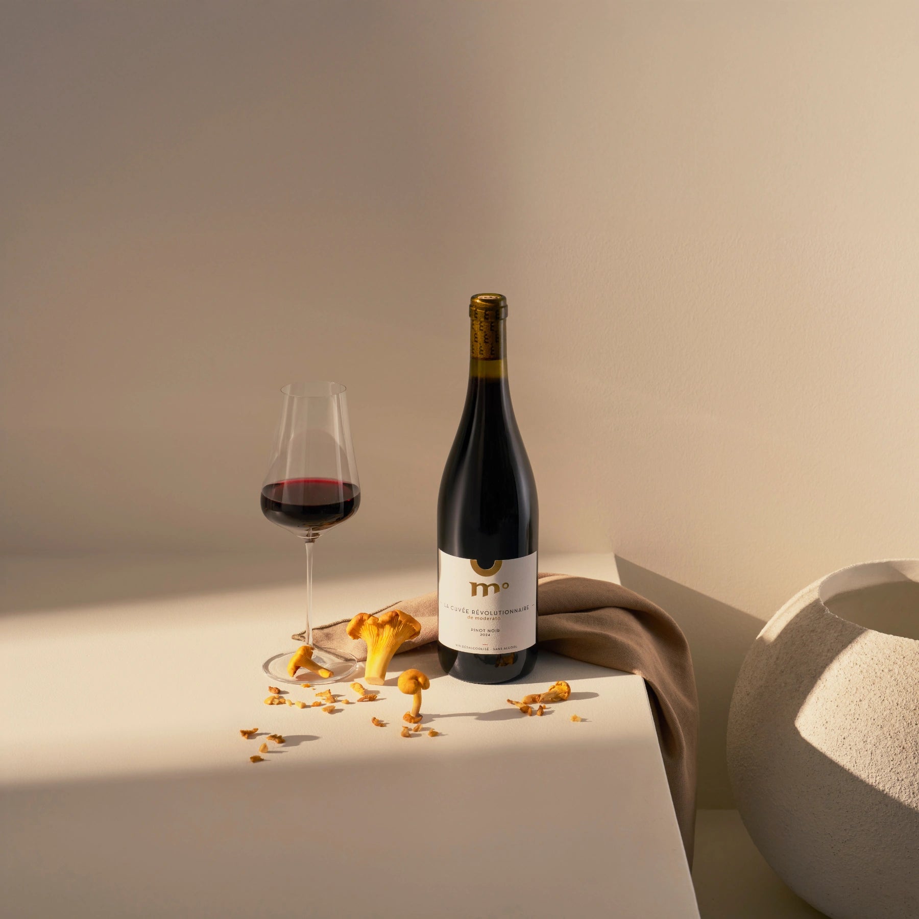 Moderato alcohol-free Pinot Noir red wine served with mushrooms in a minimal food pairing setting.