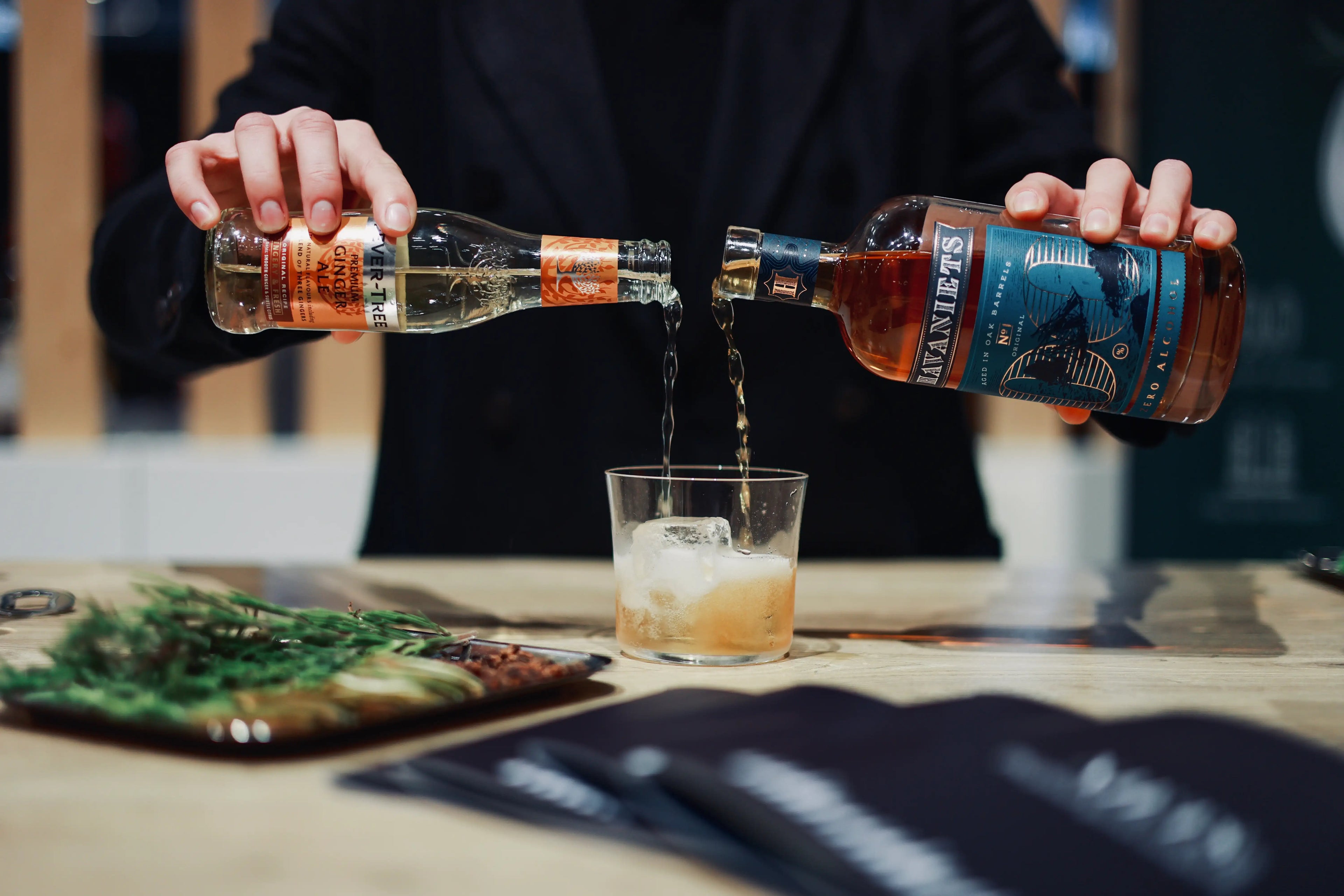 Sober Table bartender mixing a cocktail with Niets Co alcohol-free spirits including Botaniets and Havaniets.