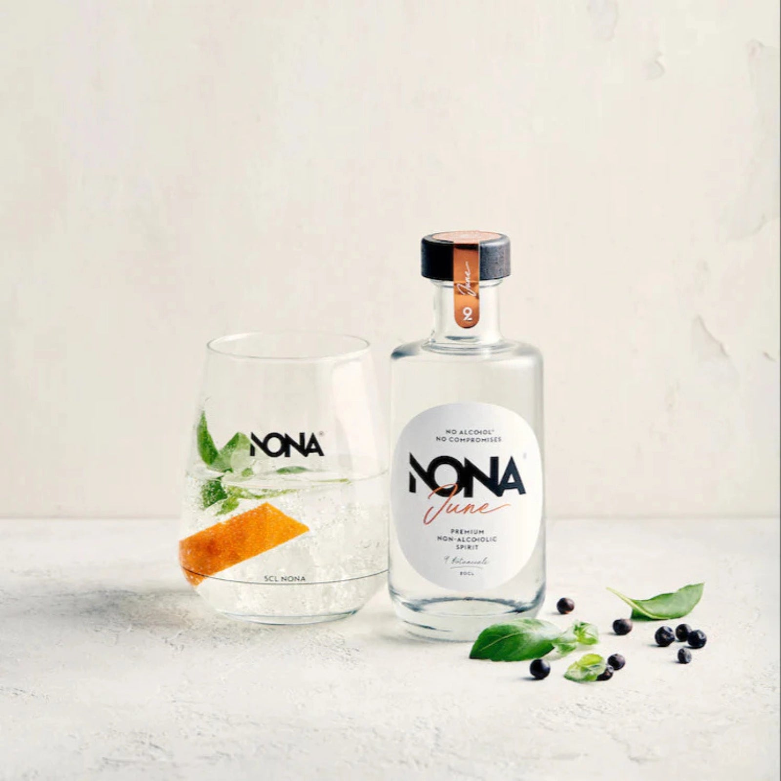 200 ml bottle of NONA June and glass of NONA June and Tonic mocktail on a light background