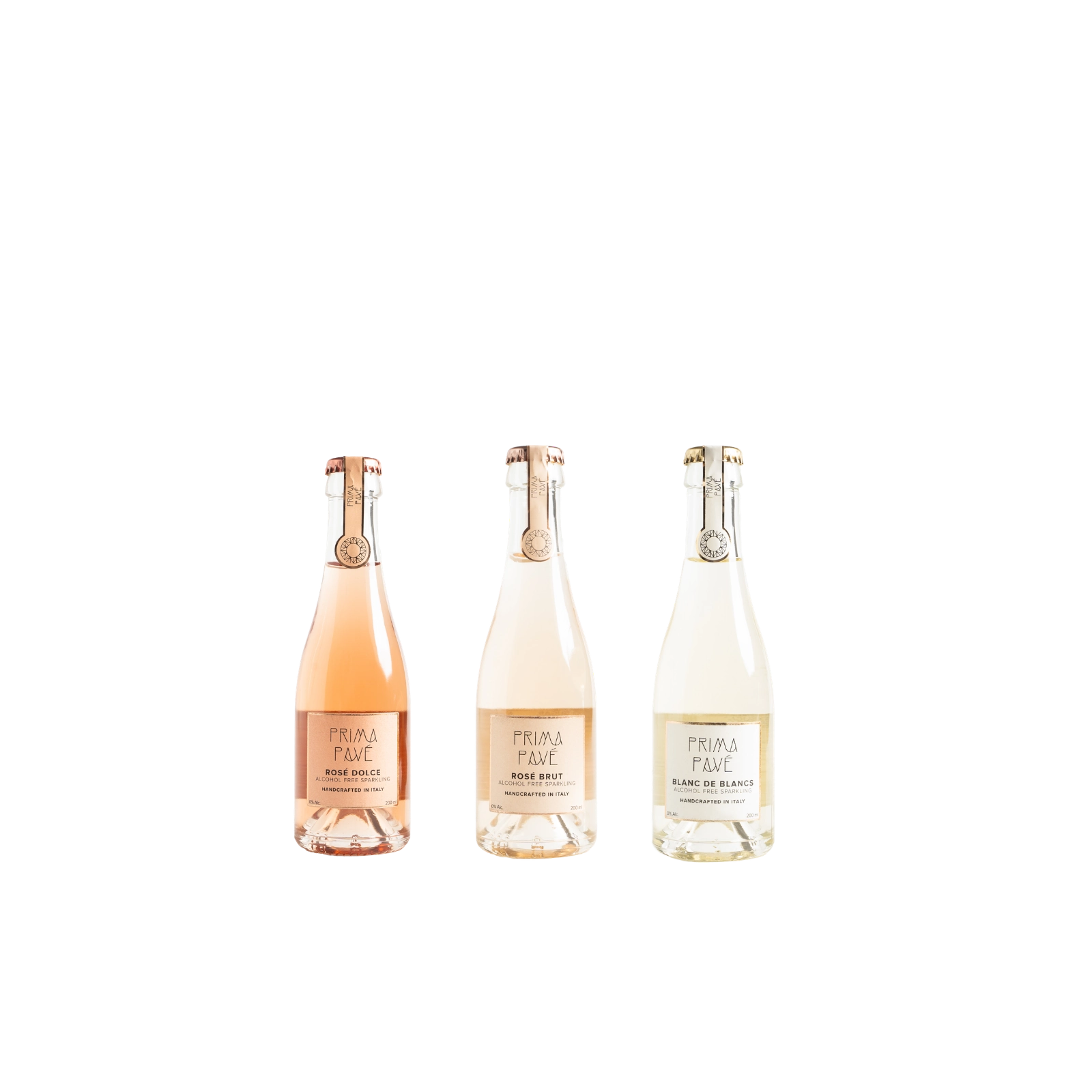 Three mini bottles of Prima Pavé alcohol-free sparkling wine: Rosé Dolce, Rosé Brut, and Blanc de Blancs, arranged on a neutral backdrop.