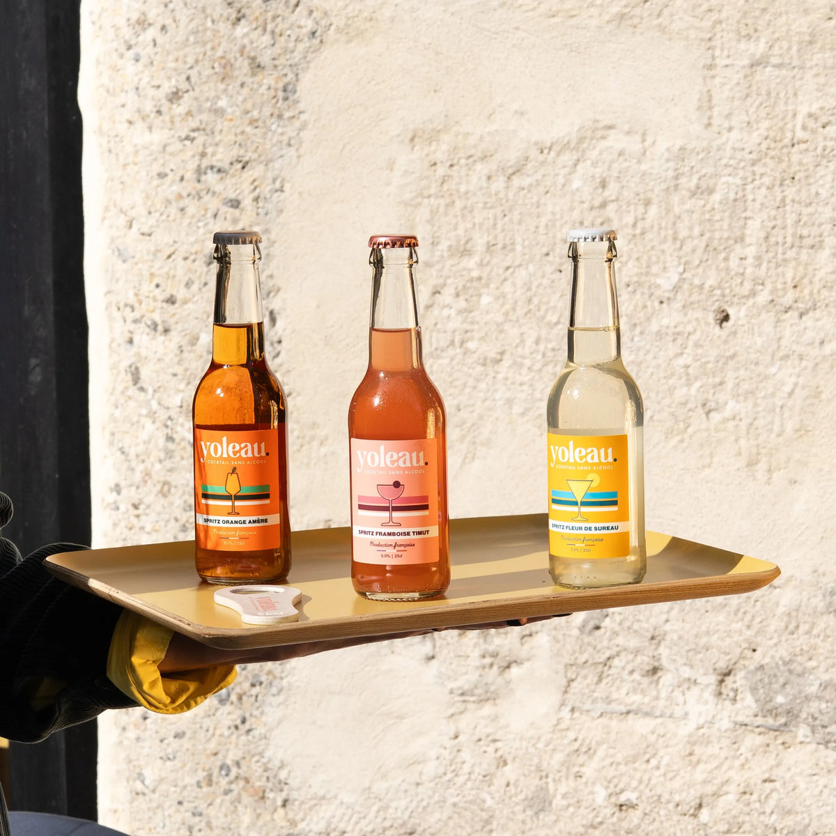 Yoleau Bitter Orange, Raspberry Timut and Elderflower alcohol-free spritz bottles displayed together on a tray.