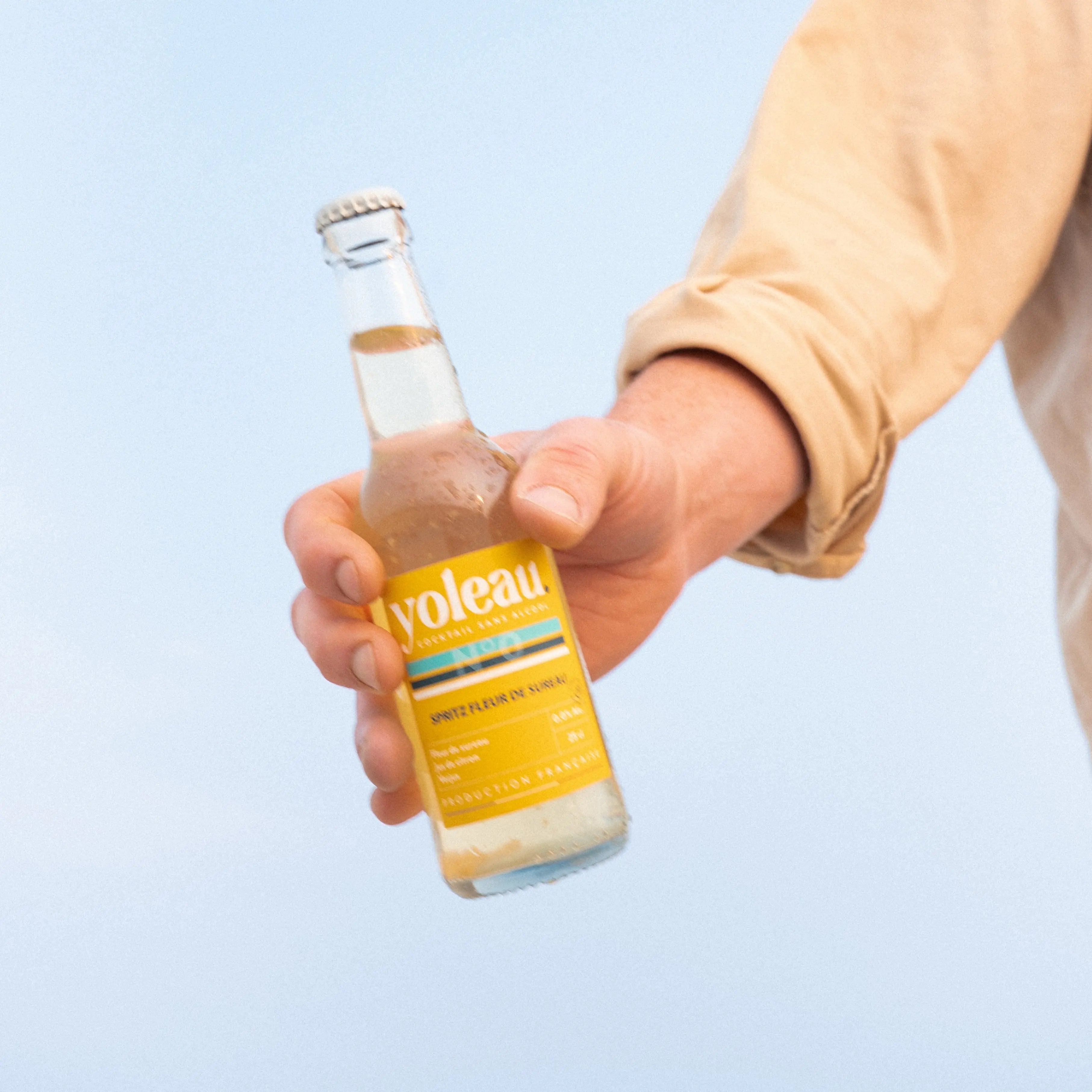 Hand holding a bottle of Yoleau elderflower spritz mocktail 250ml alcohol-free spritz drink.