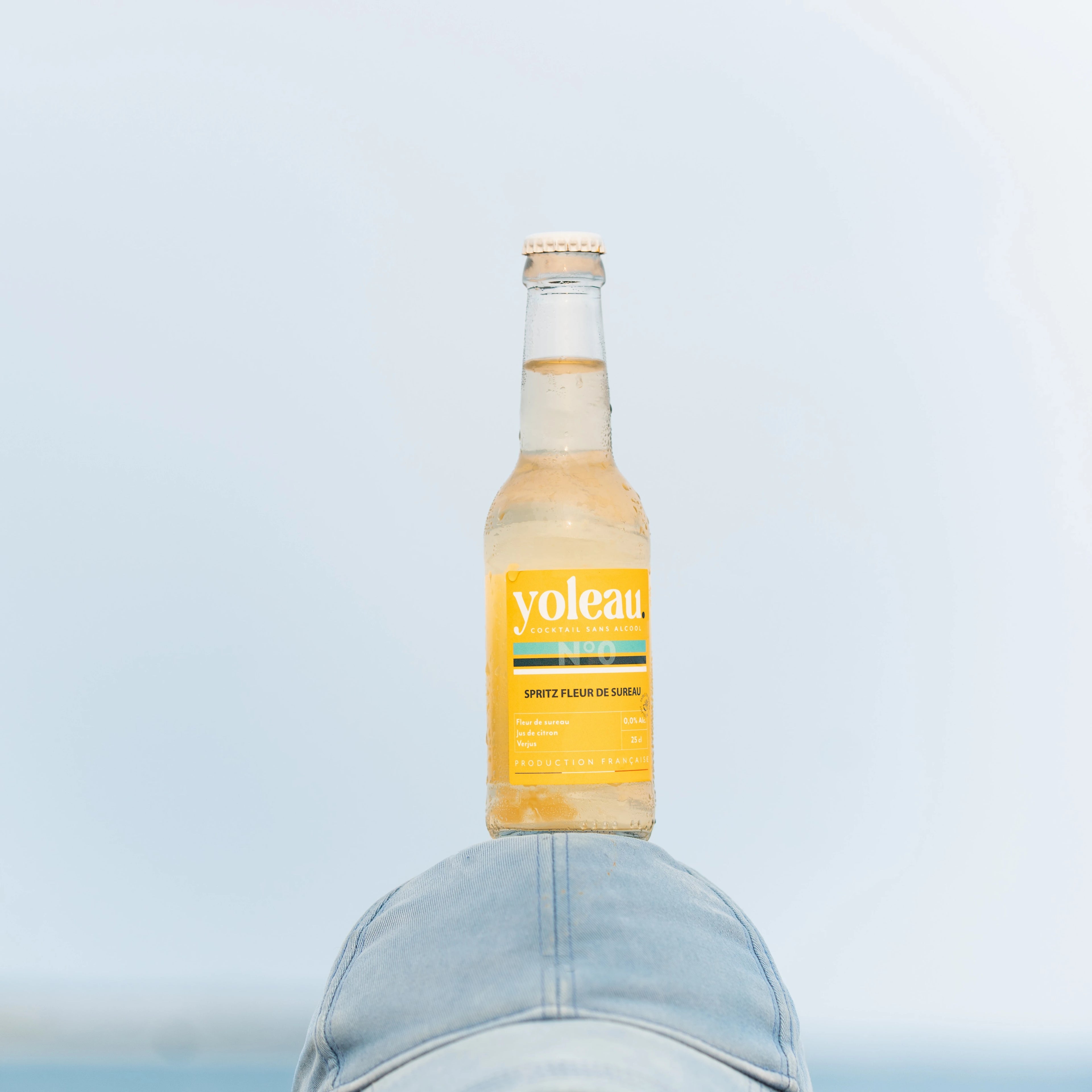Yoleau Elderflower Spritz mocktail 0.0% alcohol-free drink bottle balanced on a cap.