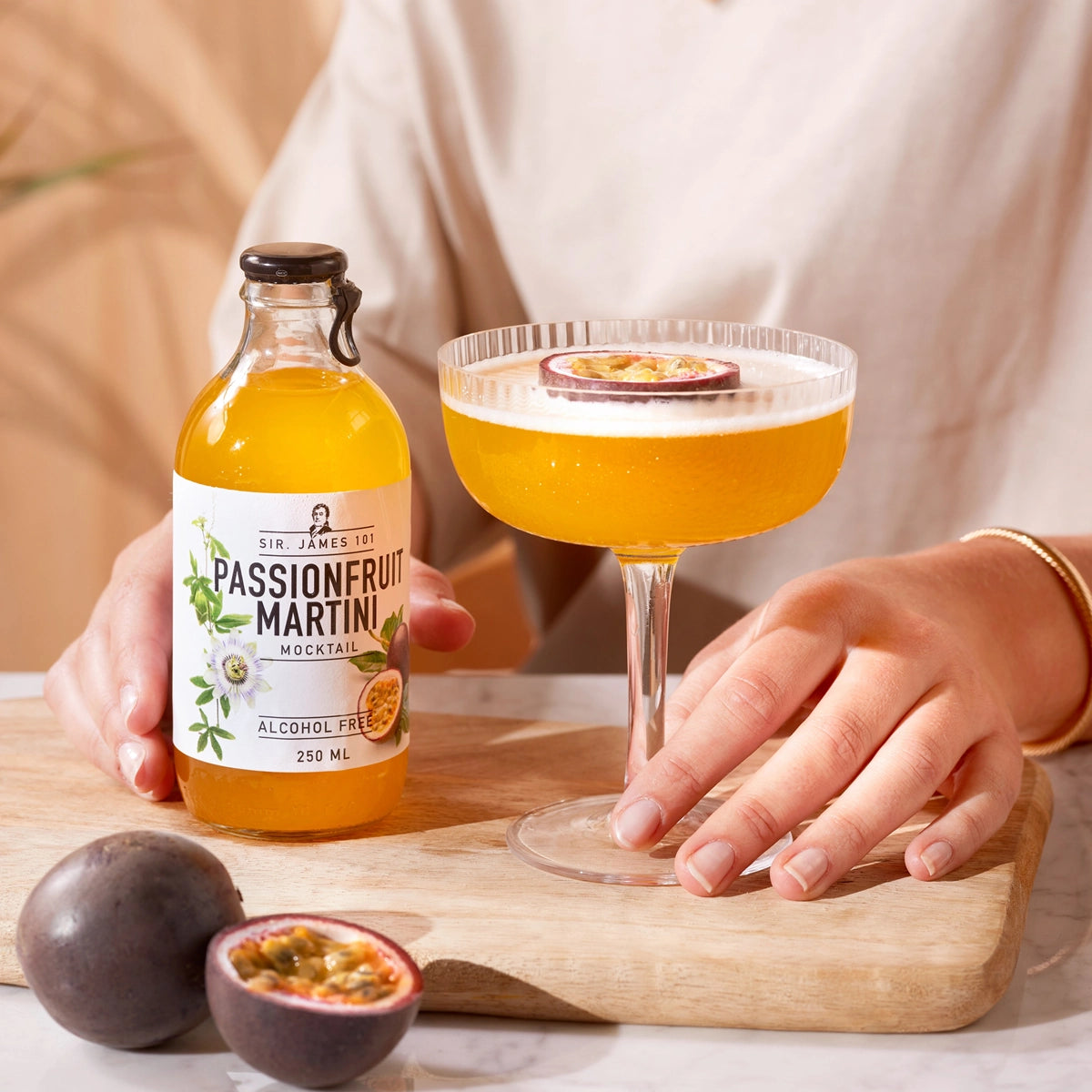 SIR. JAMES 101 Passionfruit Martini Alcohol Free 250 ml bottle with a martini glass and fresh passionfruit garnish on a wooden board.